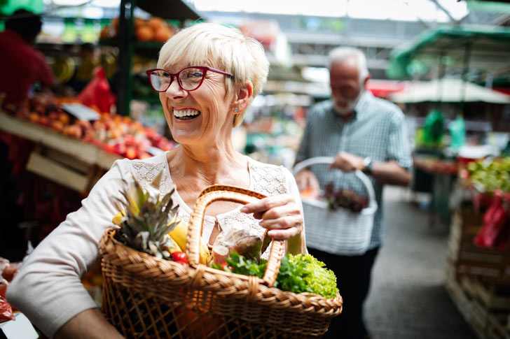 Woman holding a basket of fruit and vegetables