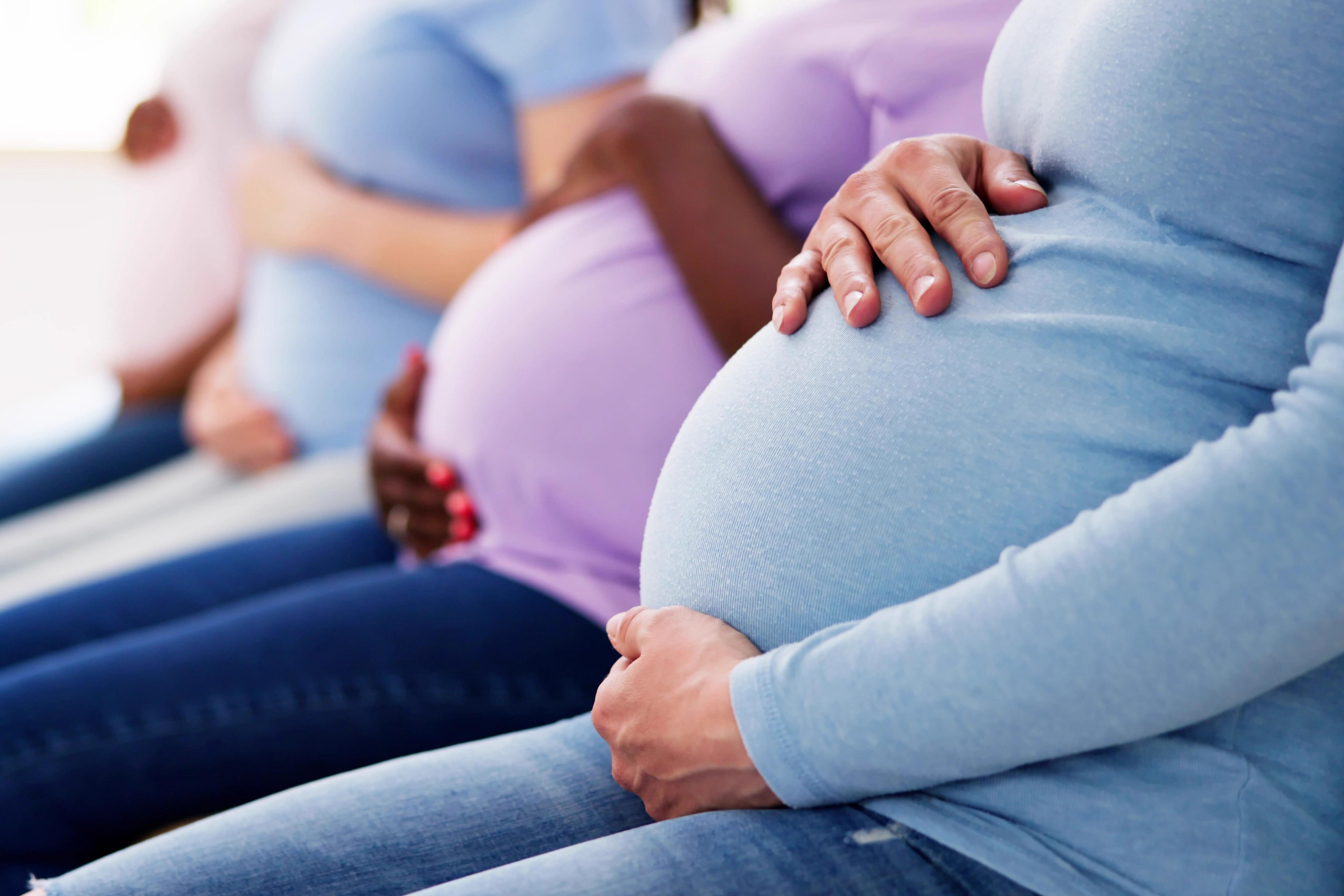 women holding pregnant bellies