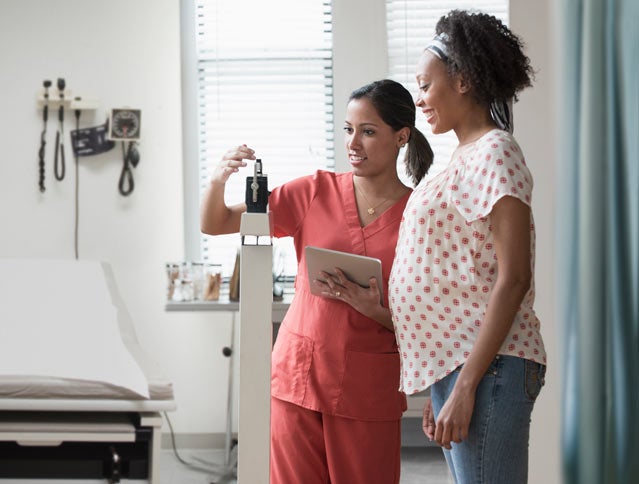 Pregnant woman getting weight checked